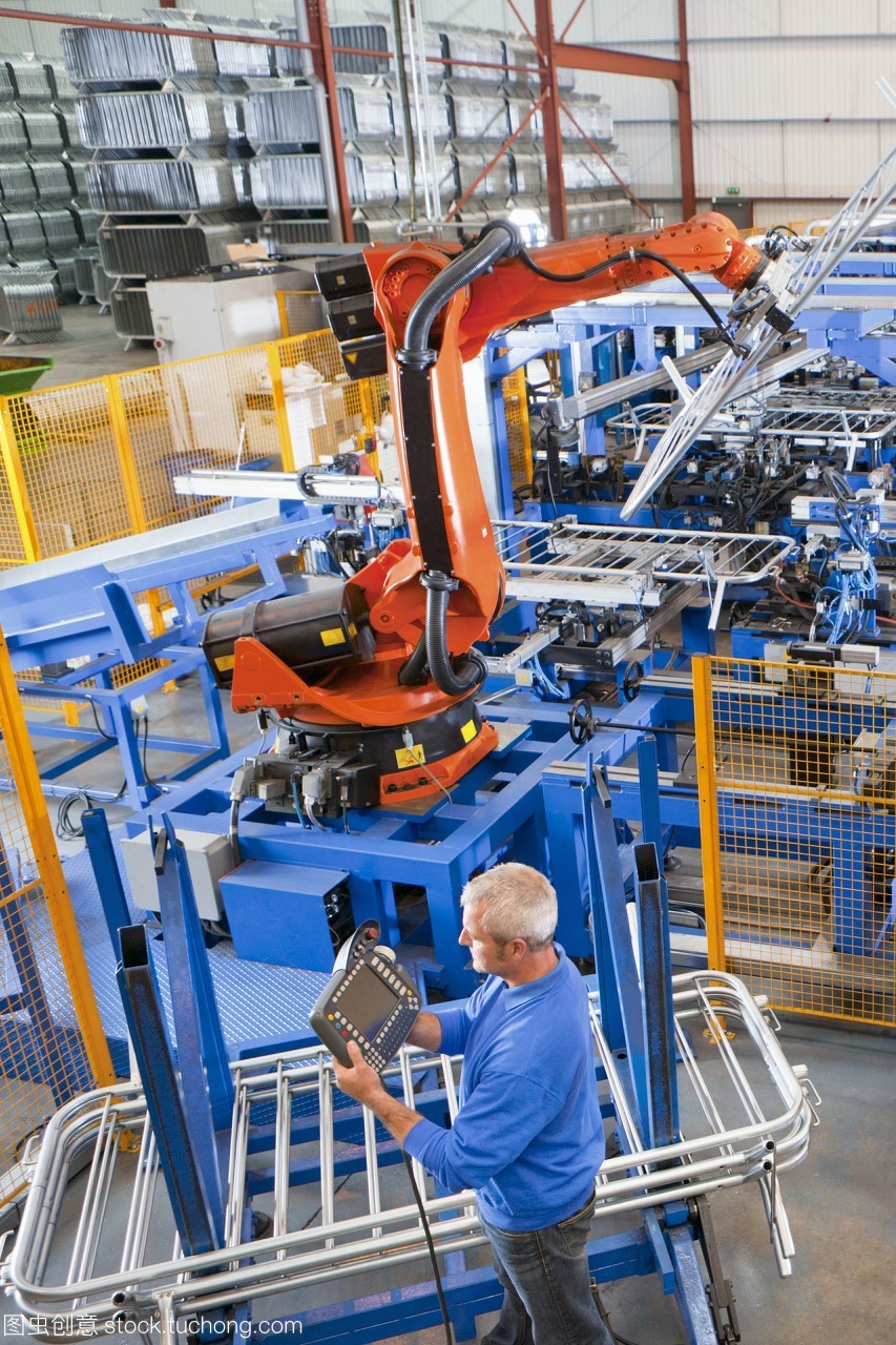 工人在制造工廠的生產(chǎn)線上控制機(jī)械吊裝